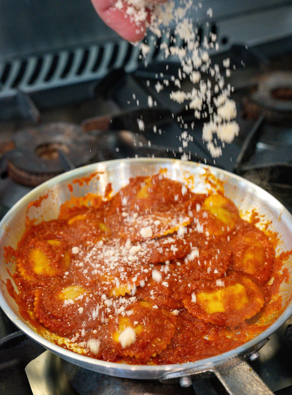 Fresh ravioli in tomato sugo with parmesan