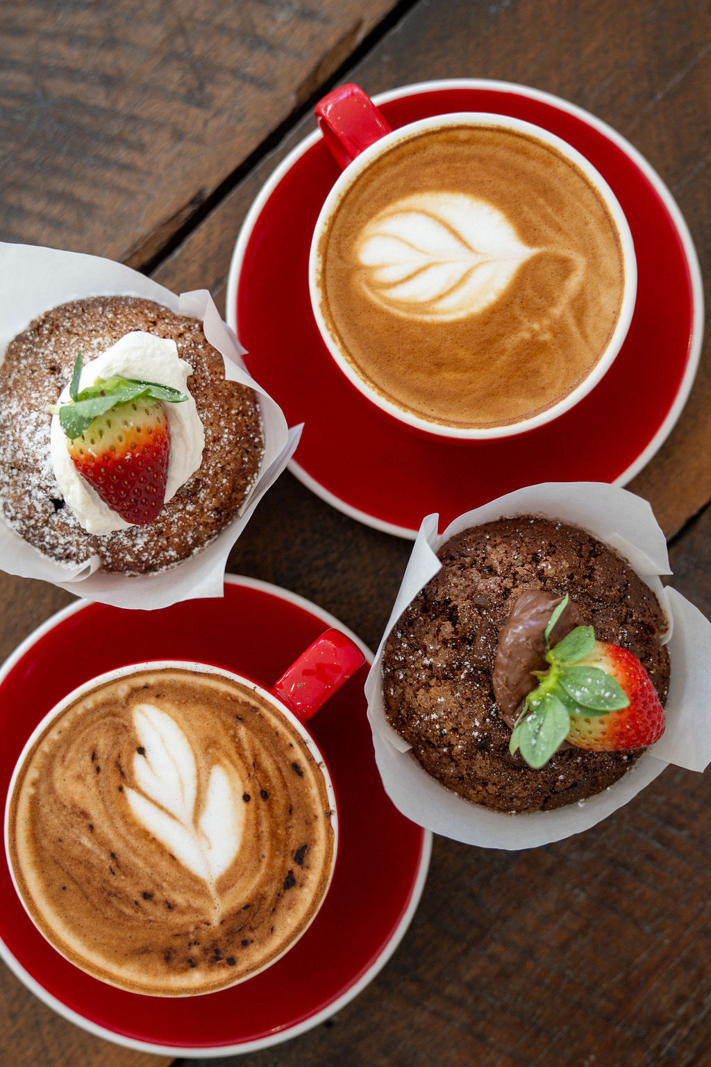 Lattes with leaf art and muffins